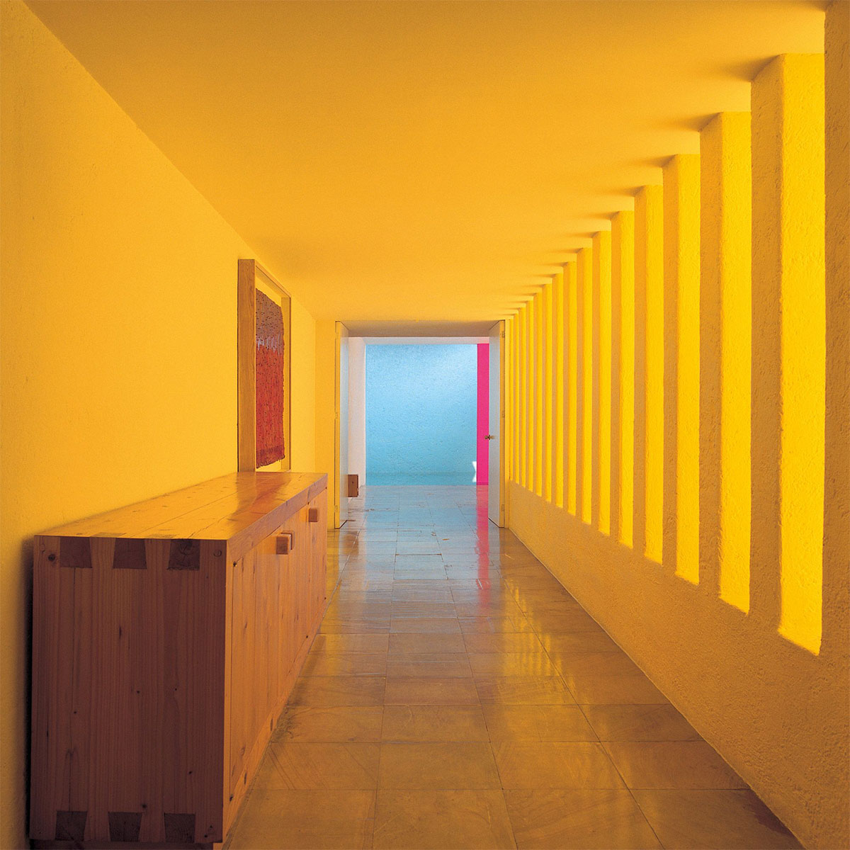 espacio arquitectónico con muros de colores intensos y luz natural dramática
