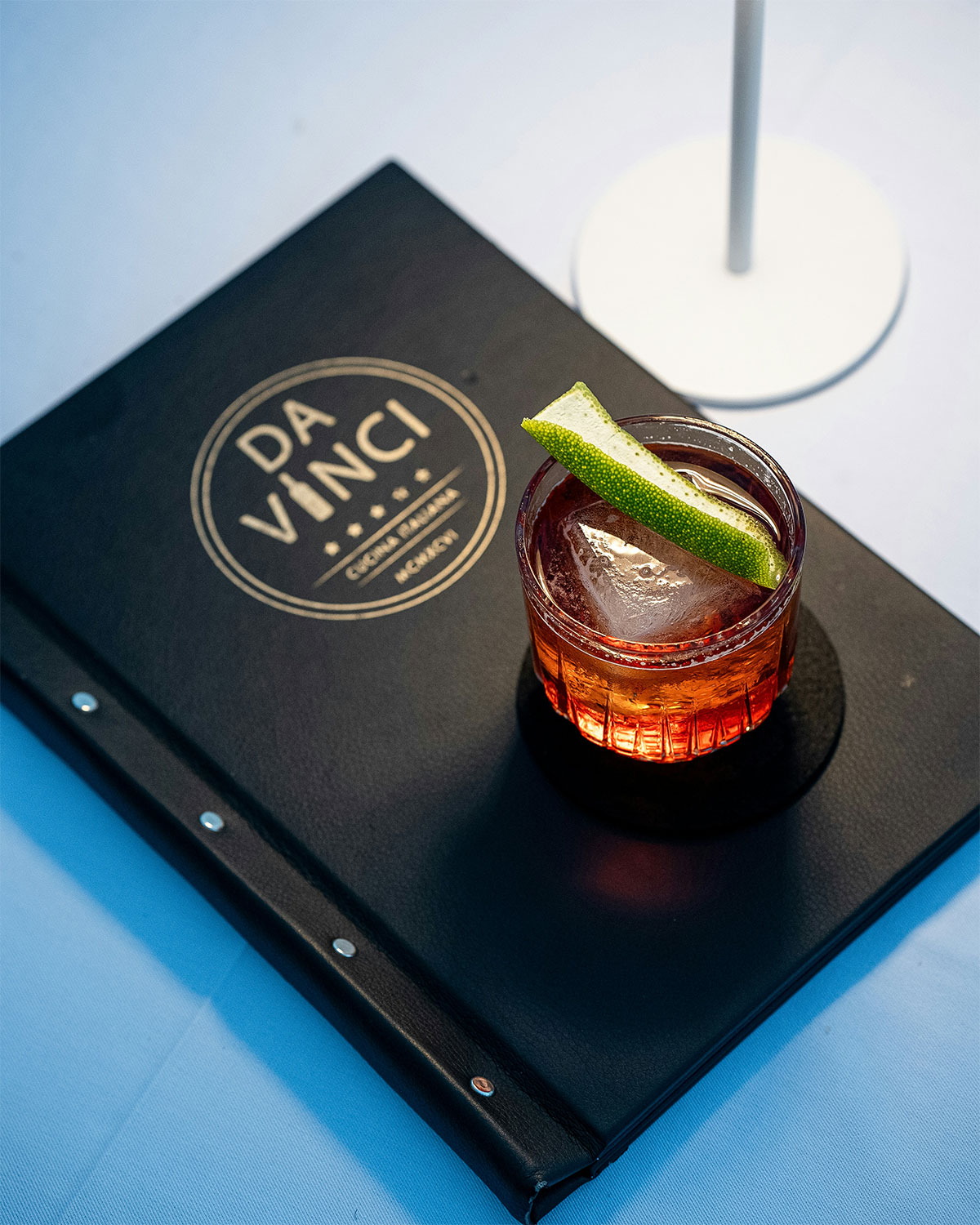 coctel con lima sobre carta de bar diseño editorial